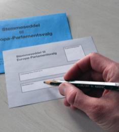 Hånd holder en blyant. På bordet under en stemmeseddel til Europa-Parlamentsvalget