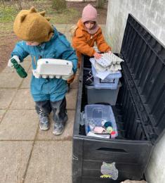 To børn holder æggebakker, som de har fundet i en åben hyndeboks