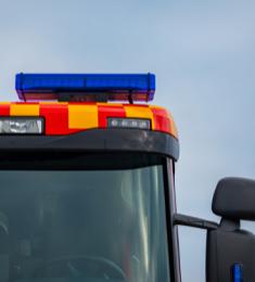 Det øverste af en brandbil ses i billedet: sirene, lys og sidespejle samt førerhuset.
