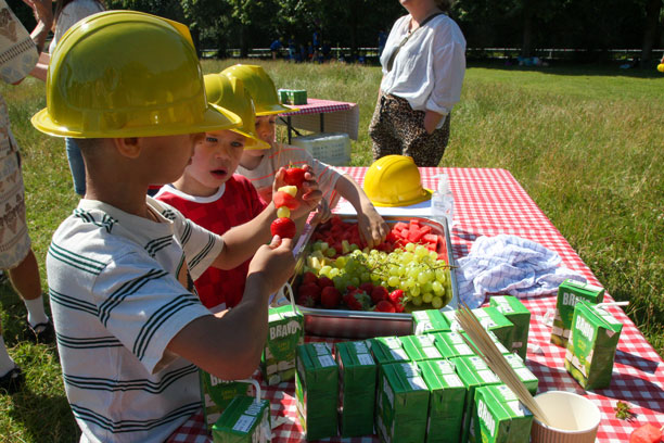 Børn står ved frugtfad og laver spyd